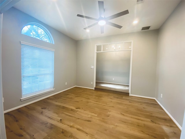 unfurnished bedroom featuring baseboards, visible vents, ceiling fan, and wood finished floors