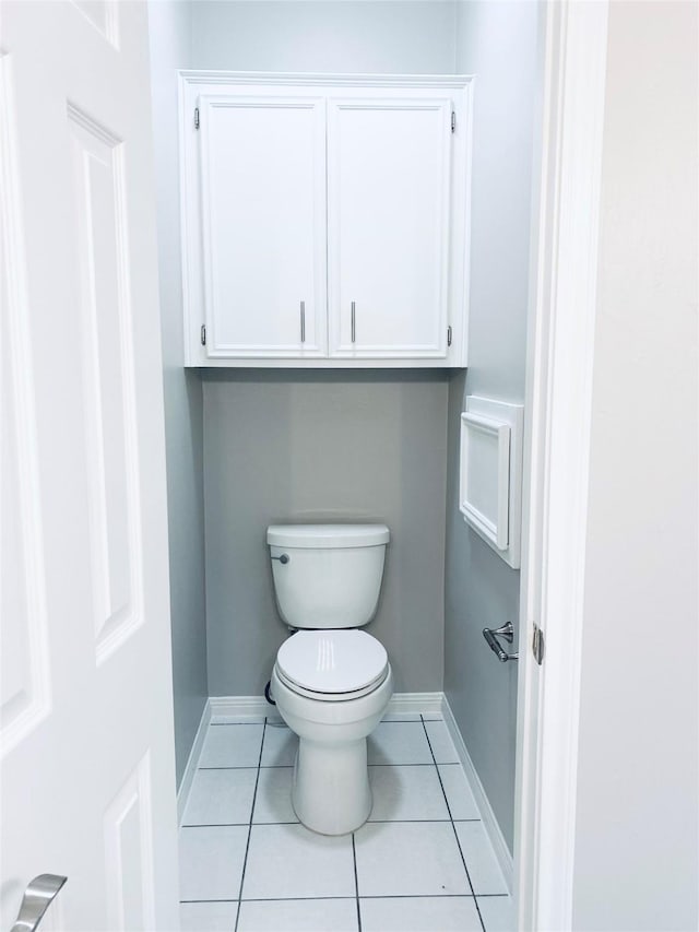 bathroom with toilet, tile patterned flooring, and baseboards