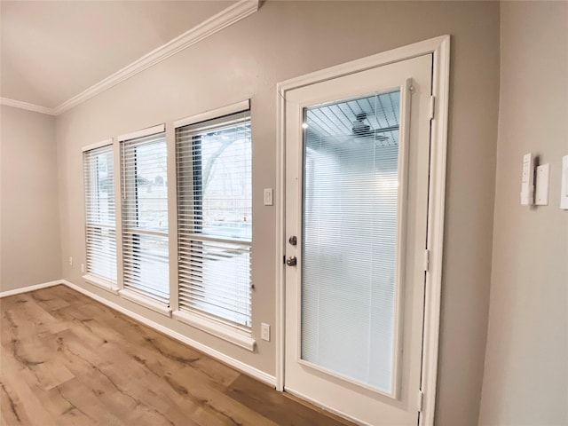 entryway with ornamental molding, light wood-style floors, and baseboards