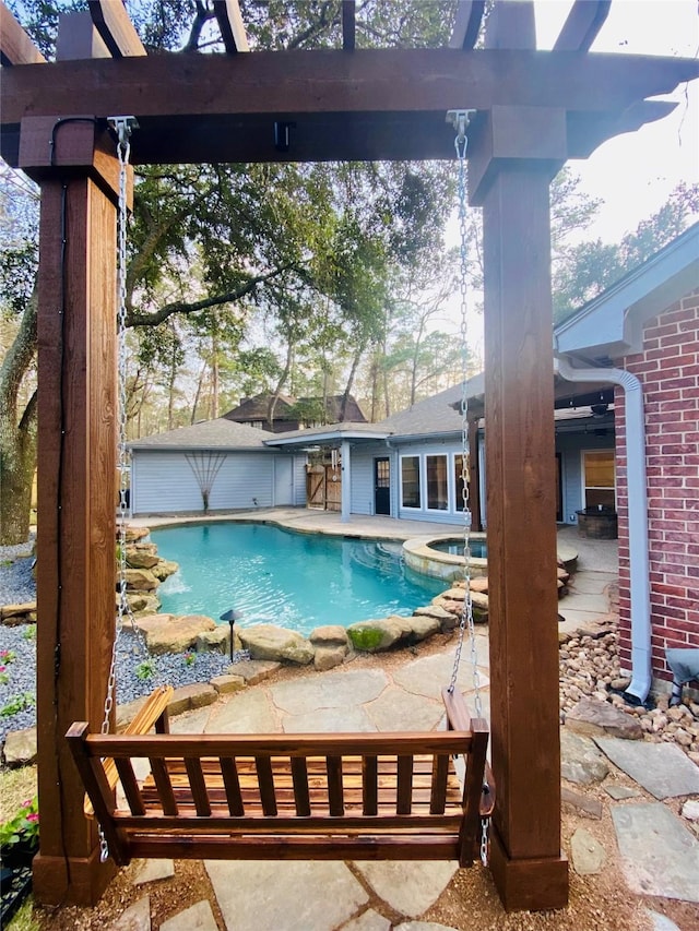 view of pool featuring a pool with connected hot tub and a patio area