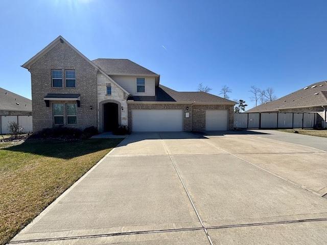 view of front of property featuring brick siding, fence, a garage, stone siding, and driveway