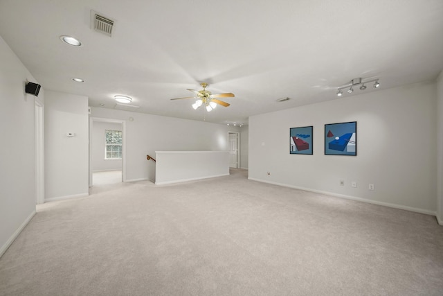 spare room featuring baseboards, ceiling fan, visible vents, and light colored carpet