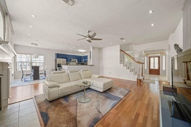 16942 Laguna Springs Dr, Houston, TX 77095 - living area with stairway, arched walkways, a ceiling fan, recessed lighting, and a textured ceiling