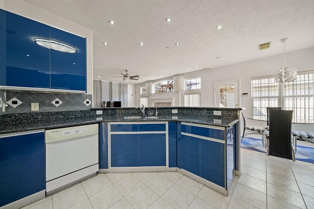 kitchen with dishwasher, open floor plan, dark stone countertops, decorative light fixtures, and a sink