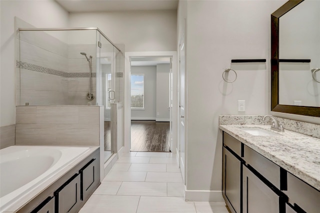 full bathroom featuring a stall shower, tile patterned flooring, a garden tub, and vanity