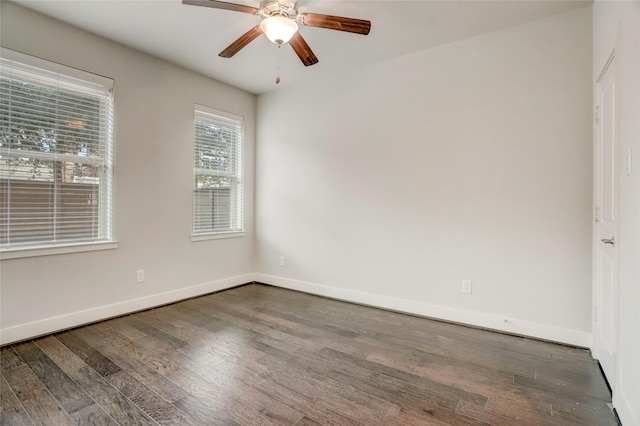 unfurnished room with baseboards, dark wood finished floors, and a ceiling fan