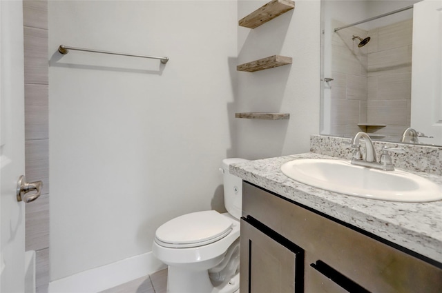 bathroom with a tile shower, tile patterned flooring, vanity, and toilet