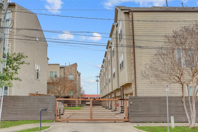 view of road with curbs and a gate