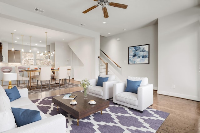 living room with recessed lighting, visible vents, stairway, light wood-type flooring, and baseboards