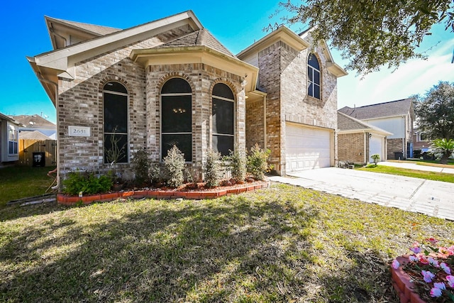 view of front of home with an attached garage, a front lawn, concrete driveway, and brick siding