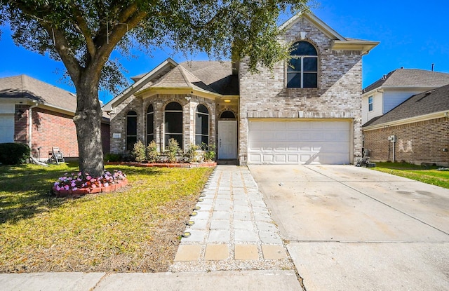 traditional-style house featuring a garage, a front lawn, concrete driveway, and brick siding