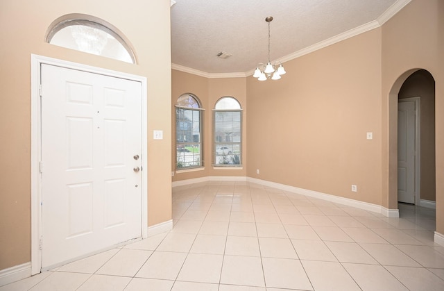 foyer featuring ornamental molding, arched walkways, a chandelier, and light tile patterned flooring