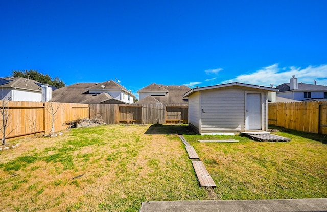 view of yard featuring an outbuilding, a shed, a fenced backyard, and a residential view