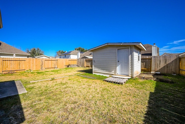 view of yard with a fenced backyard, an outdoor structure, and a shed