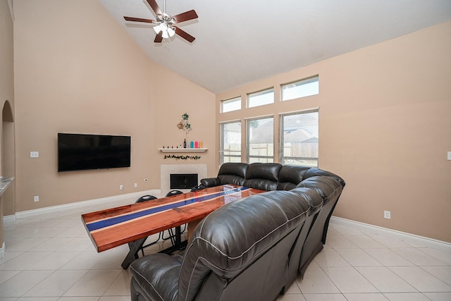 living area featuring baseboards, a fireplace, high vaulted ceiling, and light tile patterned flooring