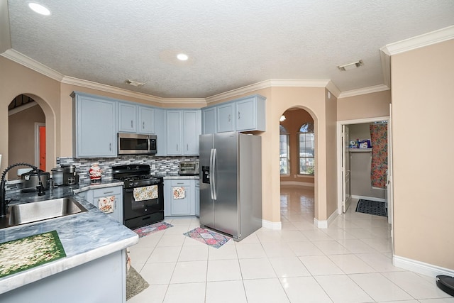 kitchen with arched walkways, stainless steel appliances, a sink, and visible vents