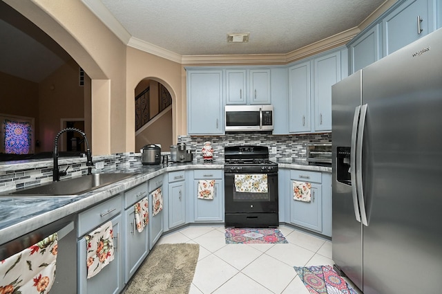 kitchen with light tile patterned floors, stainless steel appliances, a sink, and decorative backsplash