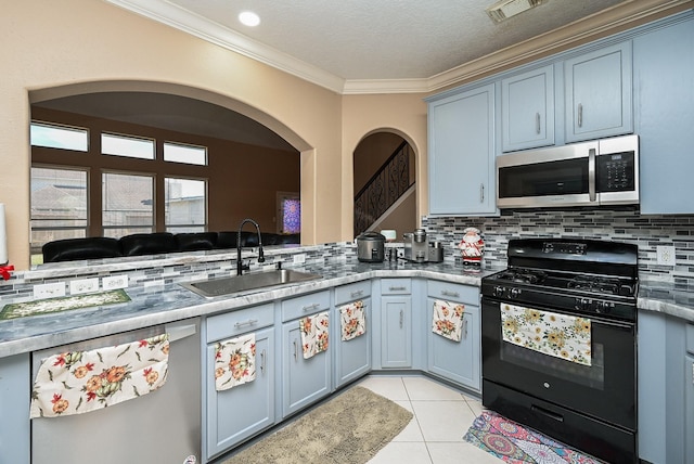 kitchen with stainless steel microwave, visible vents, light tile patterned flooring, black gas stove, and a sink