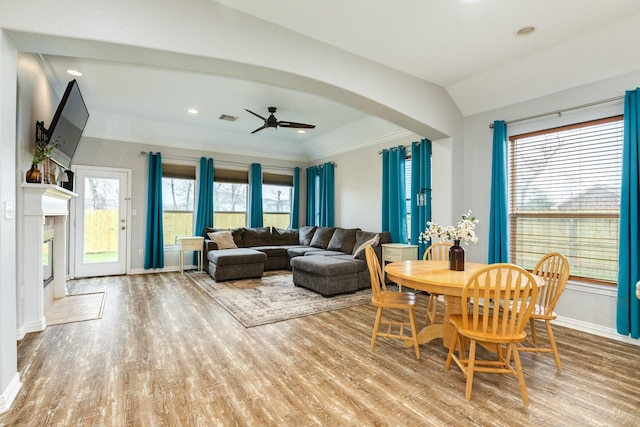 dining space featuring baseboards, visible vents, a ceiling fan, wood finished floors, and vaulted ceiling