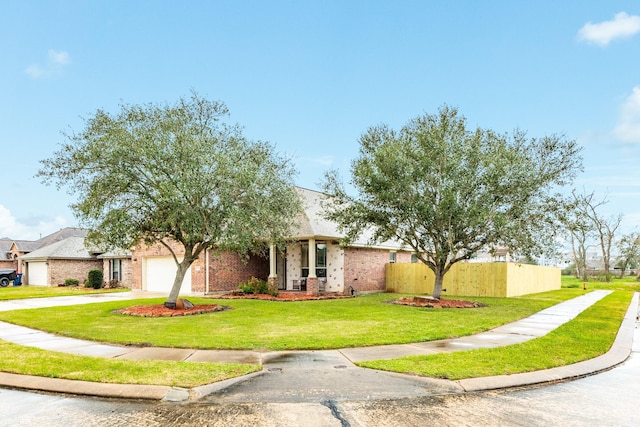 view of front facade with a garage, fence, driveway, and a front lawn