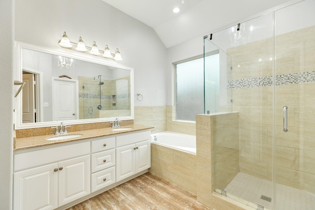 bathroom with a stall shower, lofted ceiling, and a sink