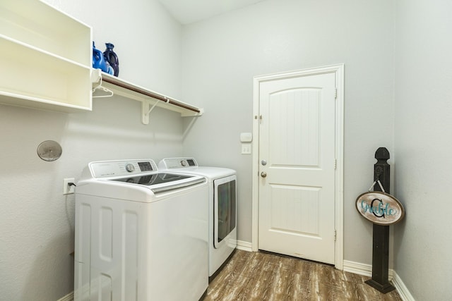 laundry area featuring laundry area, washing machine and dryer, dark wood-style floors, and baseboards