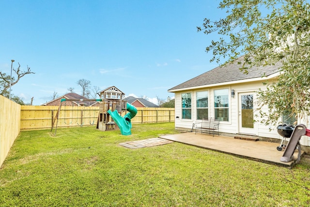 view of yard with a patio area, a playground, and a fenced backyard