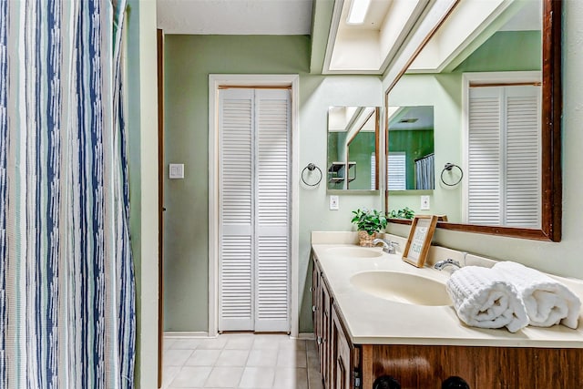 full bathroom featuring double vanity, a closet, a sink, and tile patterned floors