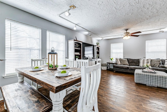 dining space featuring a textured ceiling, dark wood-type flooring, and a ceiling fan