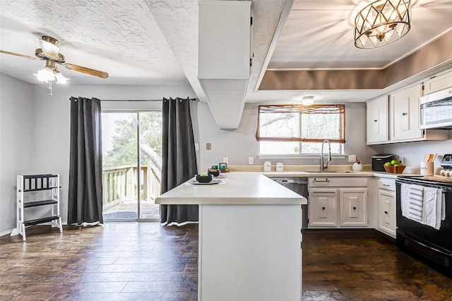 kitchen featuring white cabinets, dark wood-type flooring, stainless steel appliances, light countertops, and a sink