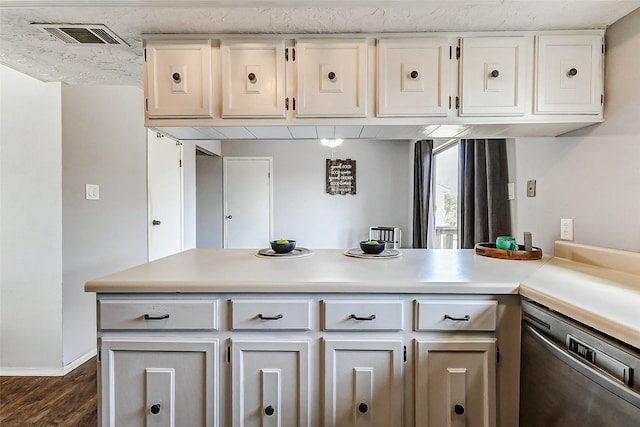 kitchen featuring dark wood-type flooring, visible vents, white cabinetry, light countertops, and stainless steel dishwasher