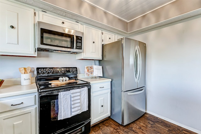 kitchen featuring dark wood-style flooring, white cabinetry, baseboards, light countertops, and appliances with stainless steel finishes