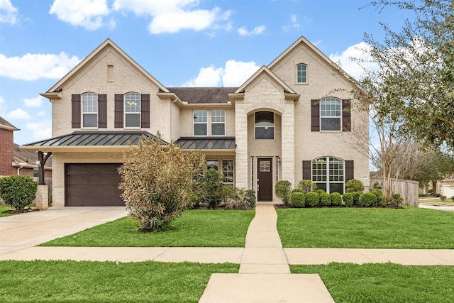 view of front of home featuring a front yard, a standing seam roof, brick siding, and concrete driveway