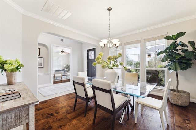 dining room featuring visible vents, arched walkways, dark wood-style flooring, and ornamental molding