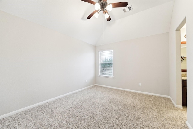 empty room featuring light colored carpet, lofted ceiling, visible vents, and baseboards