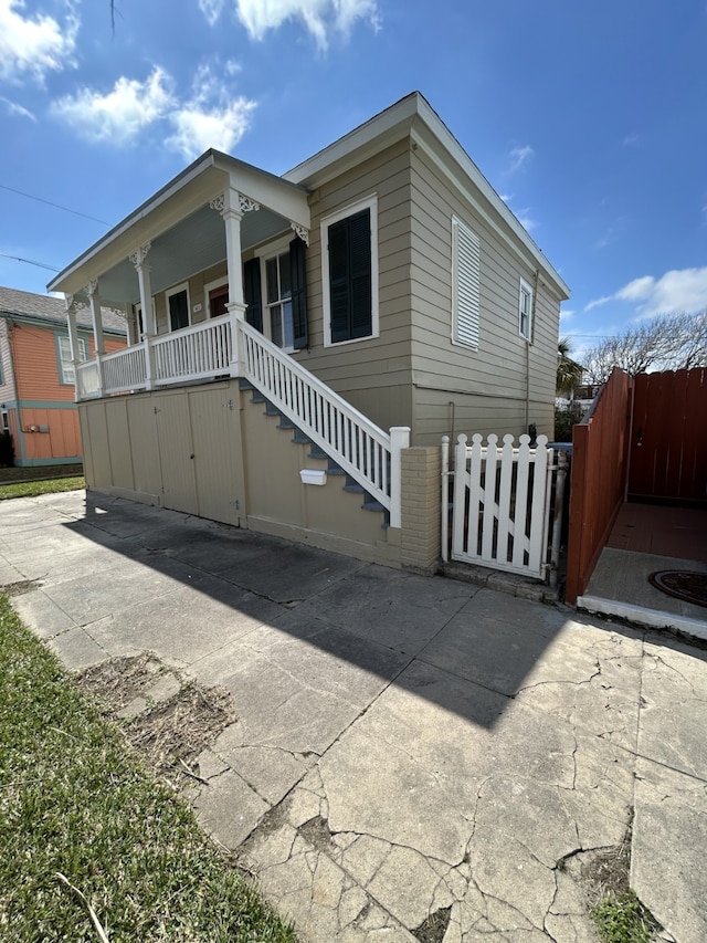 view of front facade with stairway, fence, and a porch