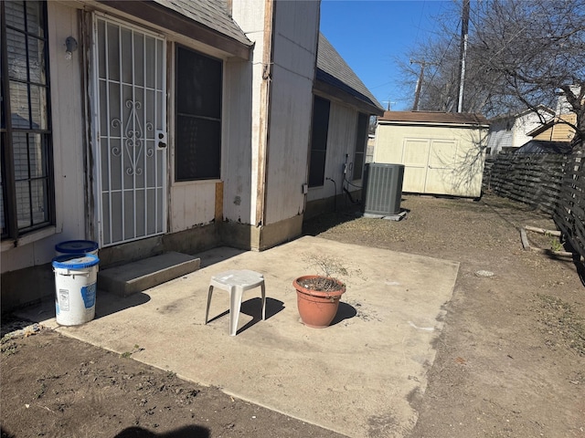 view of patio with a storage shed, an outbuilding, cooling unit, and fence