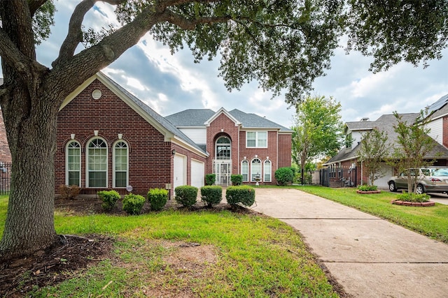 view of front of property with driveway, brick siding, a front lawn, and an attached garage