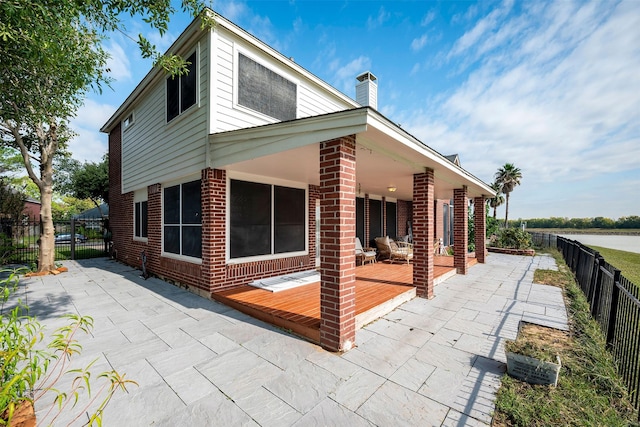 back of house with a patio area, a fenced backyard, a wooden deck, and brick siding