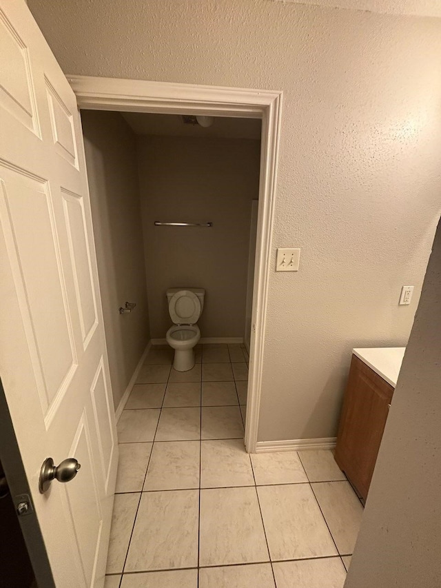 bathroom featuring baseboards, toilet, and tile patterned floors