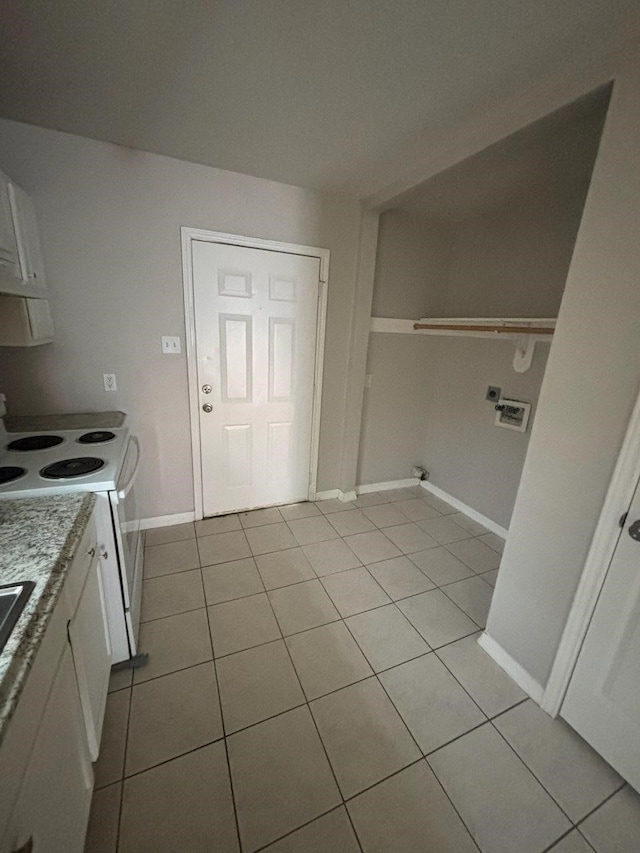 laundry room featuring light tile patterned floors, baseboards, and washer hookup