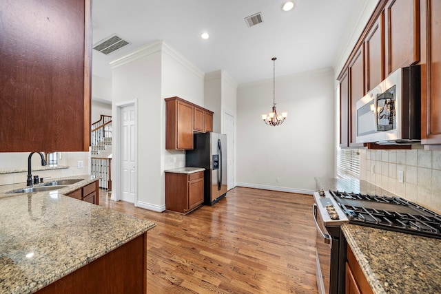 kitchen with a sink, stainless steel appliances, a notable chandelier, and visible vents