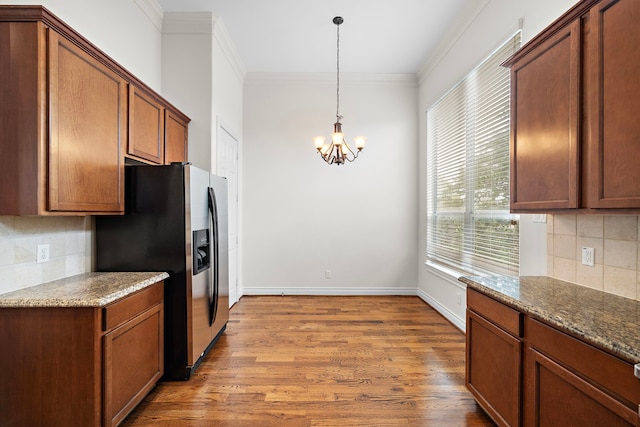 kitchen featuring baseboards, wood finished floors, stainless steel fridge, and ornamental molding