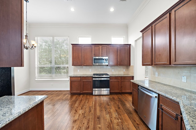 kitchen with dark wood-style floors, stainless steel appliances, tasteful backsplash, and ornamental molding