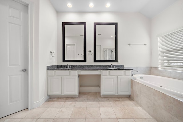 bathroom with a sink, lofted ceiling, a bath, and double vanity