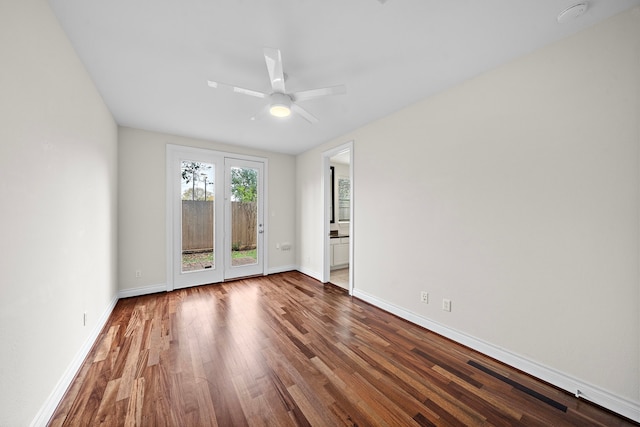 spare room with a ceiling fan, wood finished floors, and baseboards