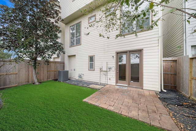 back of house featuring central air condition unit, a lawn, a patio, and a fenced backyard