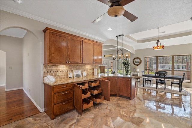 kitchen with brown cabinetry, hanging light fixtures, and a peninsula