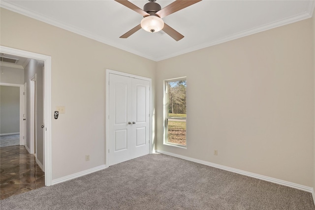 unfurnished bedroom featuring dark colored carpet, ornamental molding, visible vents, and baseboards