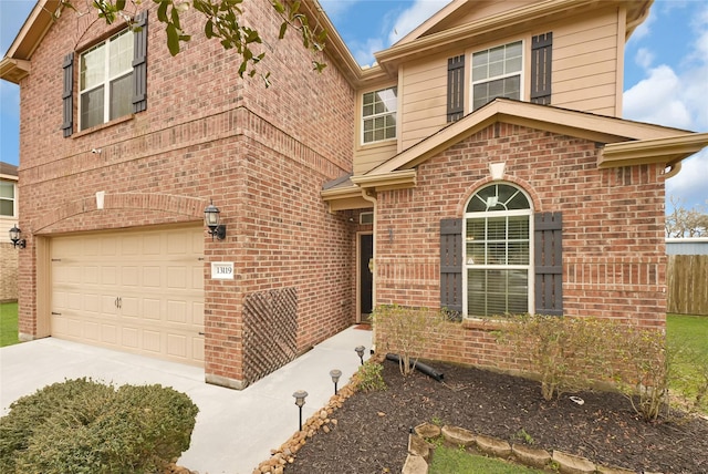 view of front of house with a garage, concrete driveway, and brick siding